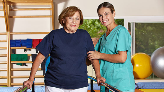 Physical therapist helping patient to walk