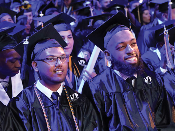Three MDC students in their cap & gown at commencement ceremony