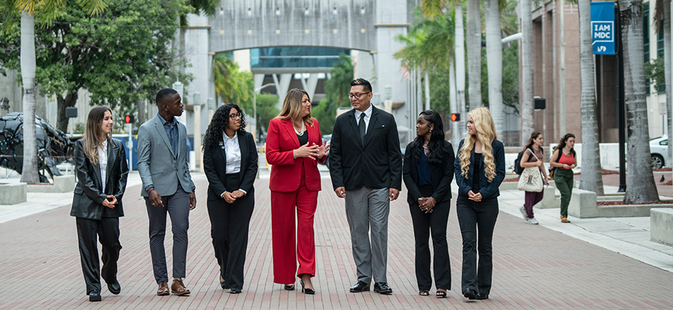 President Madeline Pumariega walking on campus with students