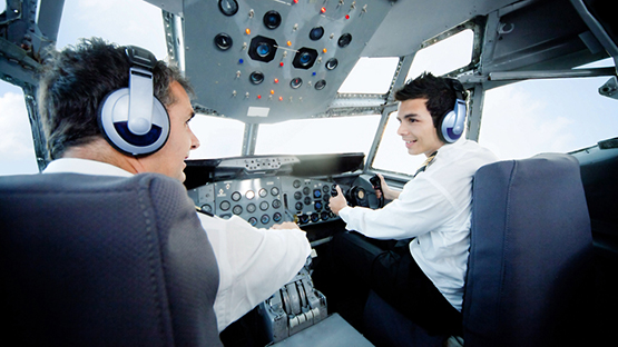 Pilots in cockpit going over the controls