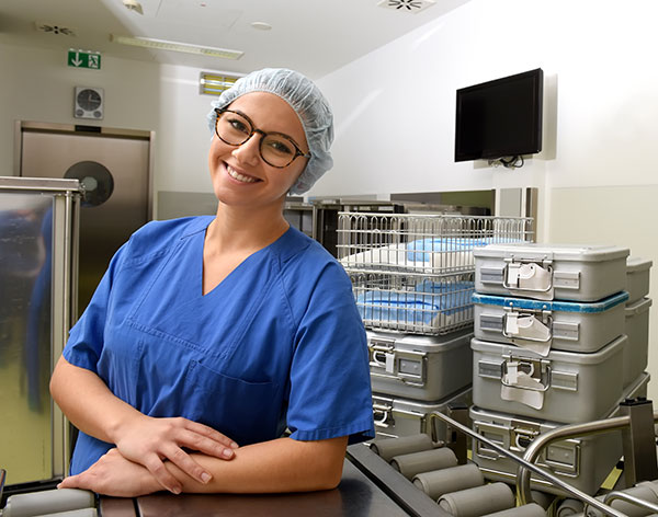 sterlile processing technician in front of sterile equipment