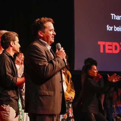 A speaker on the stage holding a microphone