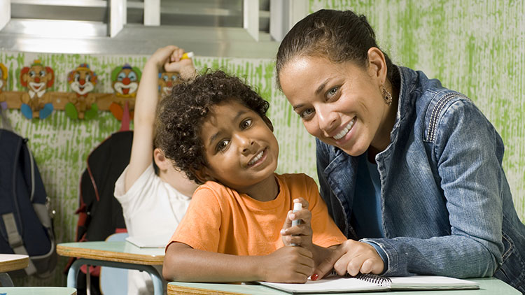 Teacher with student at a desk